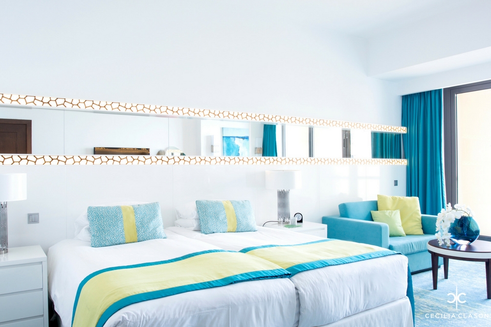 Hotel Design - White furniture on laminated blue & white textured floor with matching blue curtains & patterned wall lighting