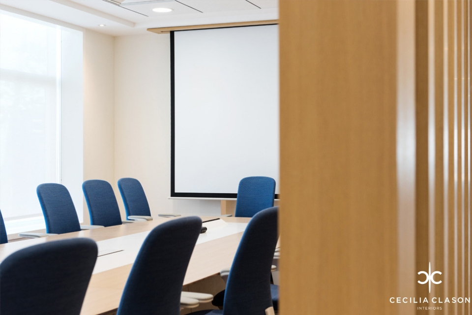 Office Interior Design - Office seen past wooden folding door, boardroom table with blue chairs and projector screene chairs and projector screen