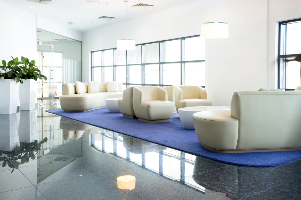 Office Lobby Interior - Cream leather sofas on & coffee tables on marble floor with multiple square framed window panes