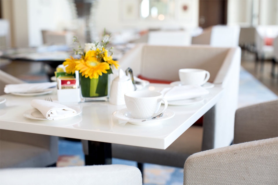 Restaurant Interior Design - Table spread with coffee cups & flower centerpiece