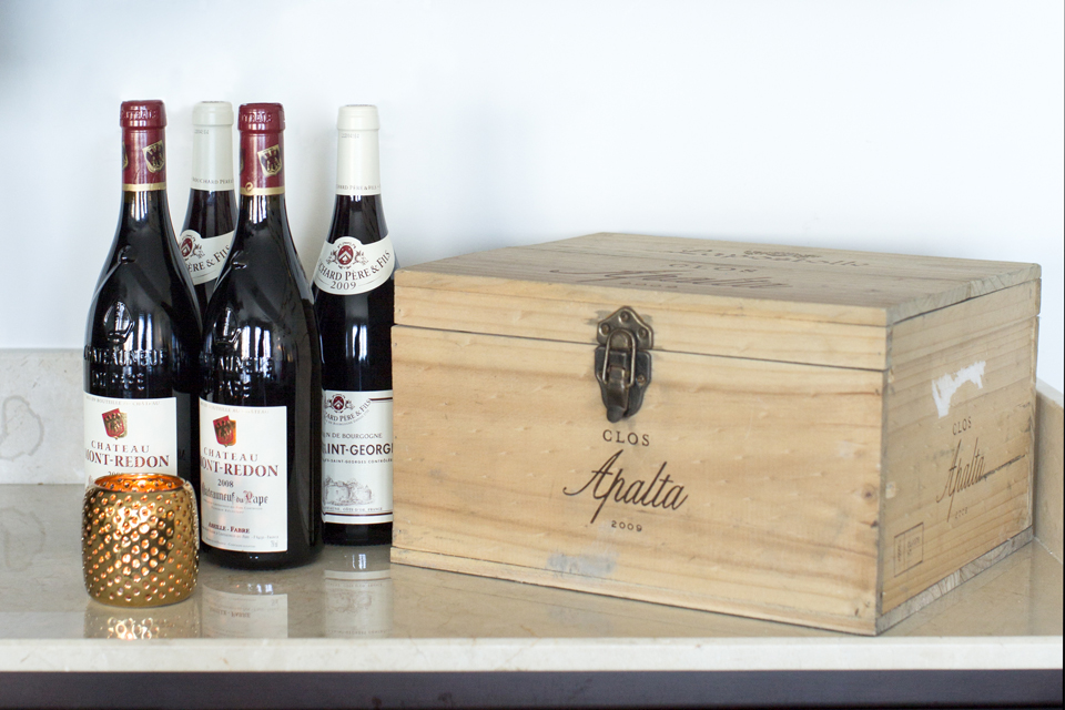 Wine Bar Decorating - Vintage wine next to wooden cigar box & gold candle holder